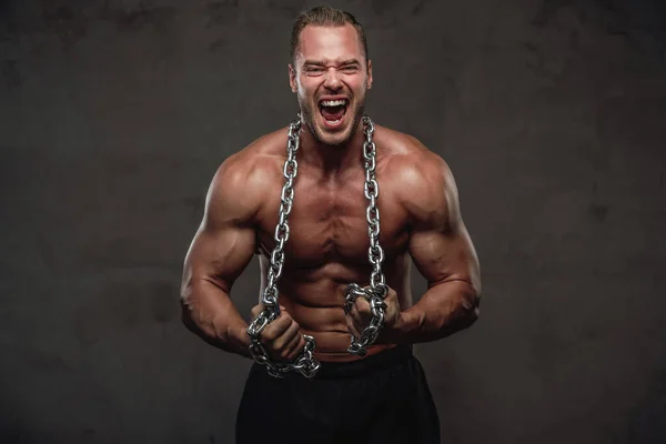 Guy with perfect body posing with chains in studio — Stock Photo, Image