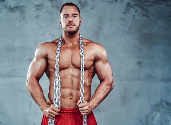 Shirtless guy with huge biceps and strong arms holding chains — Stock Photo, Image