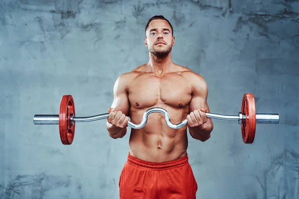 Powerful sportsman with formed body trains weightlifting — Stock Photo, Image