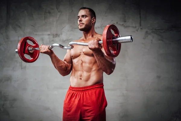 Potente deportista con cuerpo formado entrena levantamiento de pesas —  Fotos de Stock