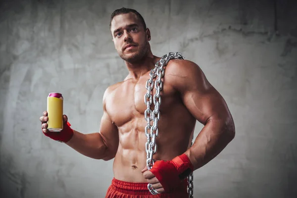 Ragazzo muscoloso con catene che tengono la sua bevanda energetica preferita — Foto Stock