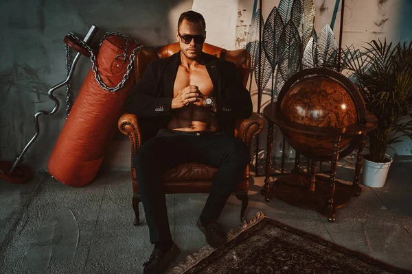 Zalim iş adamı bir sürü eşyayla aynı koltukta oturur.