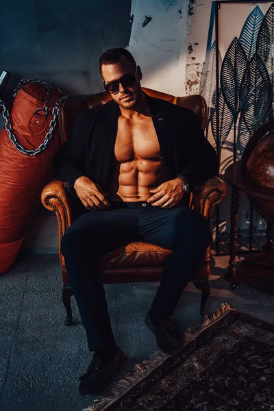 Çıplak vücutlu, sandalyede poz veren vahşi bir hippi.