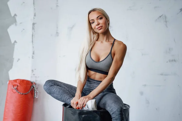 Svůdná blond sportovkyně pózující na černém sudu — Stock fotografie