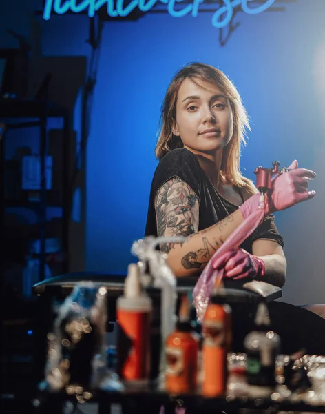 Salon de tatouage avec néons et sa propriétaire féminine — Photo