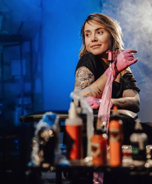 Tattoo salon with neon lights and its female owner — Stock Photo, Image