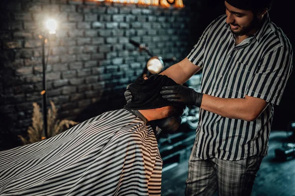 Barbeiro secando seus clientes cabelos com chapéu especial — Fotografia de Stock