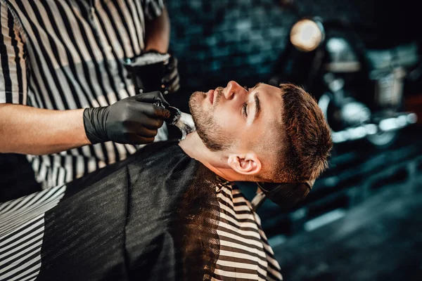 Barbeiro aplicando sabão em seu cliente em seu salão — Fotografia de Stock