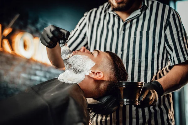 彼のサロンで彼のクライアントに石鹸を適用する理髪店 — ストック写真