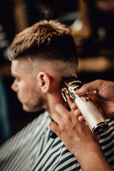 Barber cutting guys hars with silver clipper in saloon — Stock Photo, Image