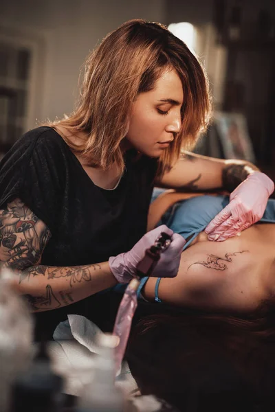 Chica vino al maestro del tatuaje para dibujar olas en su hombro — Foto de Stock