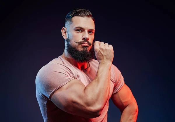 Stylish bodybuilder touches his mustache and posing — Stock Photo, Image