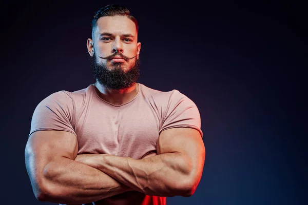 Brutal bearded sportsman posing in dark background — Stock Photo, Image