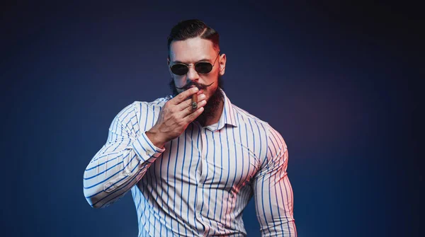 Eleganter Bodybuilder im Hemd posiert mit Zigarre in der Hand — Stockfoto