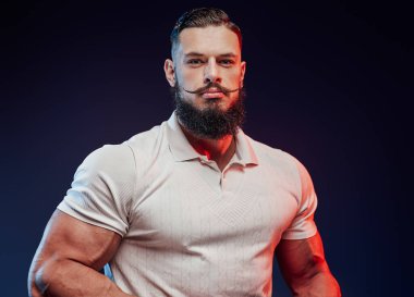 Şık saç stili olan atlet koyu arkaplanlı gömlekle poz veriyor