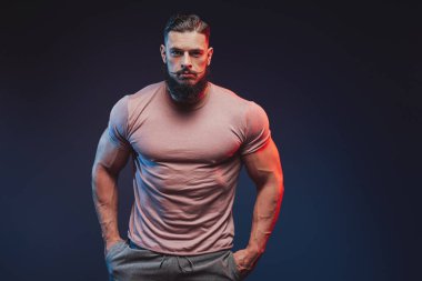 Sakallı, esmer görünümlü yakışıklı bir vücut geliştirici.