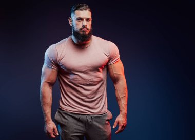 Sakallı, esmer görünümlü yakışıklı bir vücut geliştirici.