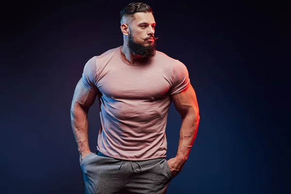 Muskulöser bärtiger Typ im Hemd bleibt im dunklen Hintergrund — Stockfoto