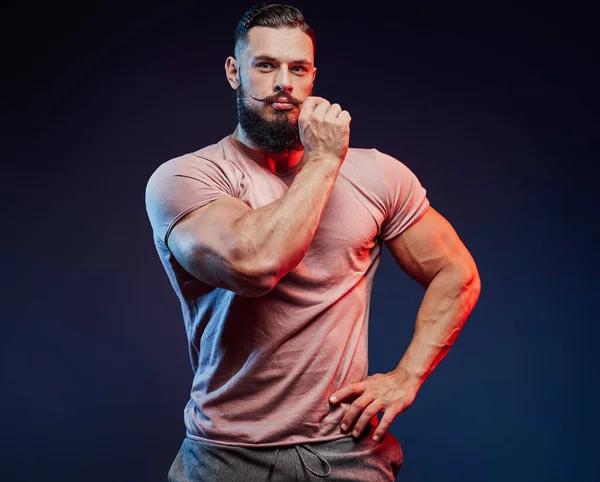 Fashionable muscular athlete with beard touches his mustache — Stock Photo, Image