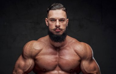Karanlık arka planda çıplak vücut pozu veren güçlü bir adam.