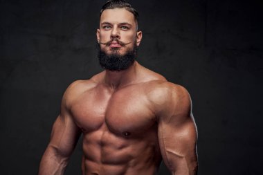 Gri arka planda sakallı yakışıklı bir sporcu.
