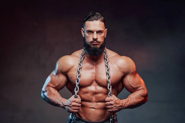 Bodybuilder mit Bart hält Stahlketten und posiert — Stockfoto