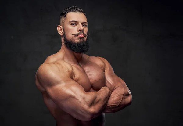 Bodybuilder med skägg poserar med korsade armar i studio — Stockfoto