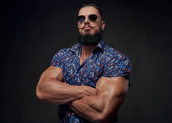 Trendig kroppsbyggare med stora biceps poserar med korsning händer — Stockfoto