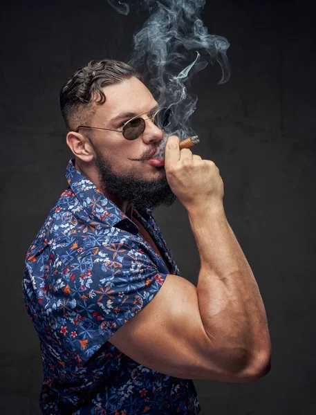 Self confident bodybuilder in glasses posing with cigar — Stock Photo, Image