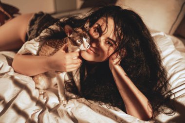 Lüks, sıcak bir daire ve dalgalı saçlı bir kadınla kedi.