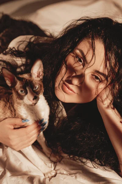Lüks, sıcak bir daire ve dalgalı saçlı bir kadınla kedi. — Stok fotoğraf