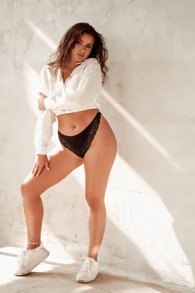 Curly haired female model posing near wall — Stock Photo, Image