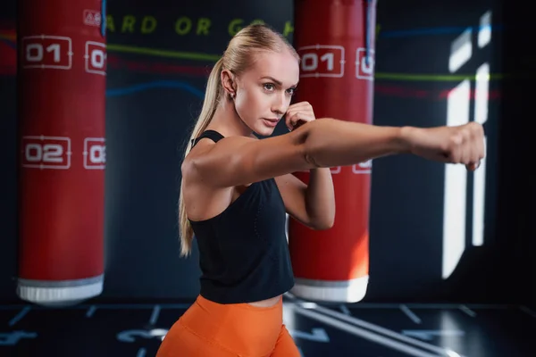 Slim sportswoman exercising in modern boxing gym — Stock Photo, Image
