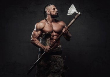 Viking dövüşçüsü baltasına bakarak poz veriyor.