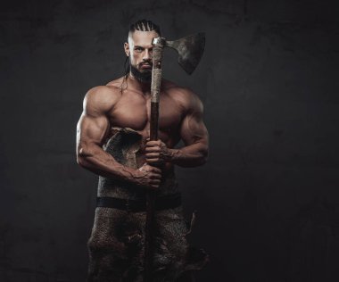 Siyah arka planda Viking gibi giyinmiş kaslı adam.