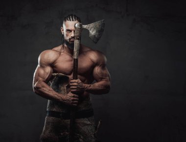 Siyah arka planda Viking gibi giyinmiş kaslı adam.
