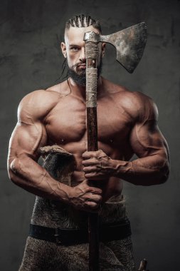 Siyah arka planda Viking gibi giyinmiş kaslı adam.