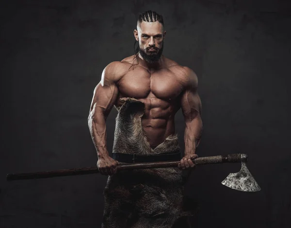 Heavy warrior with serios face posing with axe in studio — Stock Photo, Image