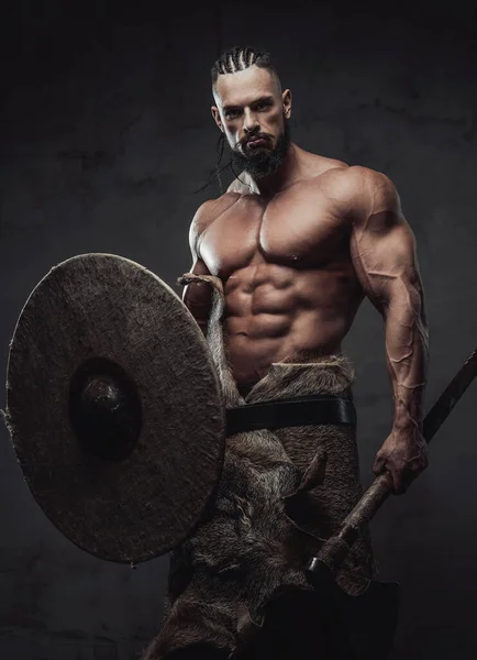 Brutal viking poserar holdingsköld och yxa i studio — Stockfoto