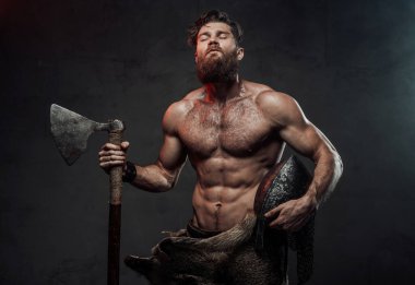 Karanlık arka planda balta ve miğferli Ortaçağ Vikingleri