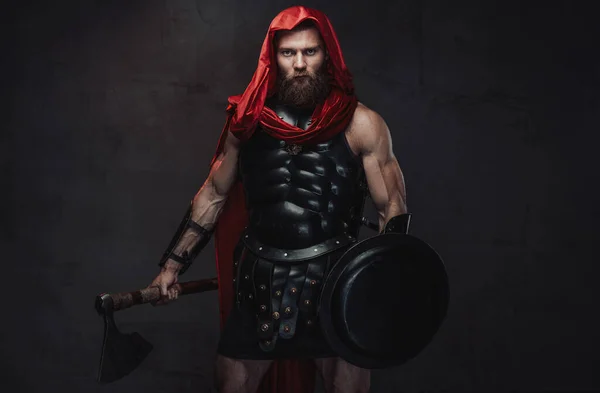 Kriegerischer Römer mit Kapuze posiert in dunklem Raum mit Scheinwerfer — Stockfoto