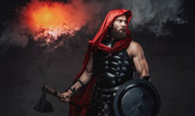 Siyah ekipmanlarla karanlık odada poz veren Roma savaşçısı