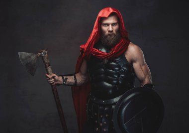 Karanlık odada sahne ışıklarıyla poz veren kapüşonlu Savaşçı Romalı