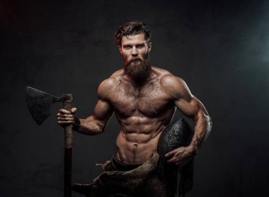 Karanlık arka planda balta ve miğferli Ortaçağ Vikingleri