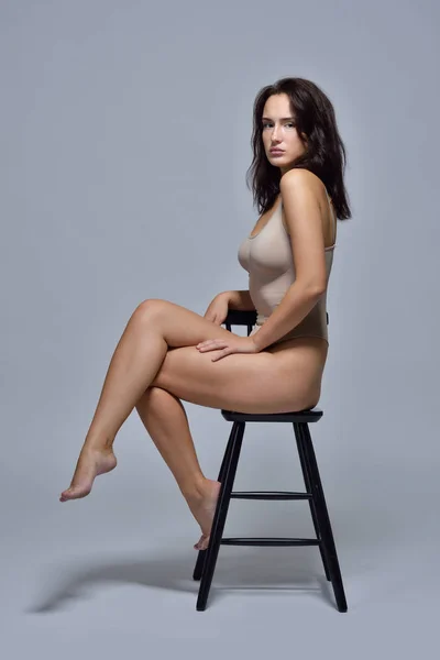 Mooie vrouw in ondergoed zittend op de stoel. — Stockfoto