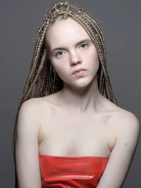 Schöne blonde junge Frau mit Zöpfen in rotem Top — Stockfoto