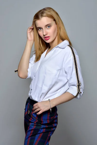 Beautiful blonde woman in white shirt and checked trousers — Stock Photo, Image