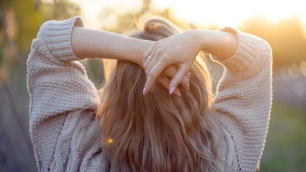 Leuk charmant meisje in de zomer in het veld. Jonge vrouw is blij en voelt gratis buitenshuis. Achteraanzicht — Stockfoto