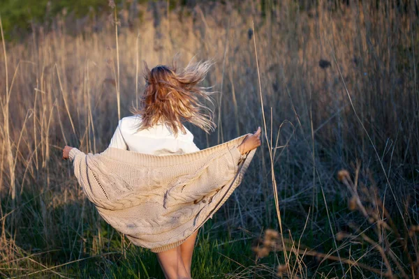 A rapariga está a acabar. Jovem no campo, sinta liberdade e felicidade. Estilo casual. Visão traseira — Fotografia de Stock