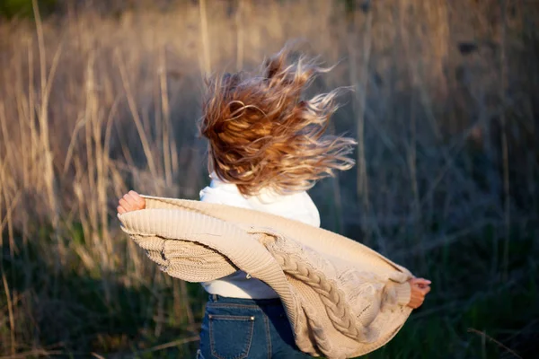 Meisje loopt uit. Jonge vrouw in het veld, gevoel vrijheid en geluk. Casual stijl. Achteraanzicht — Stockfoto